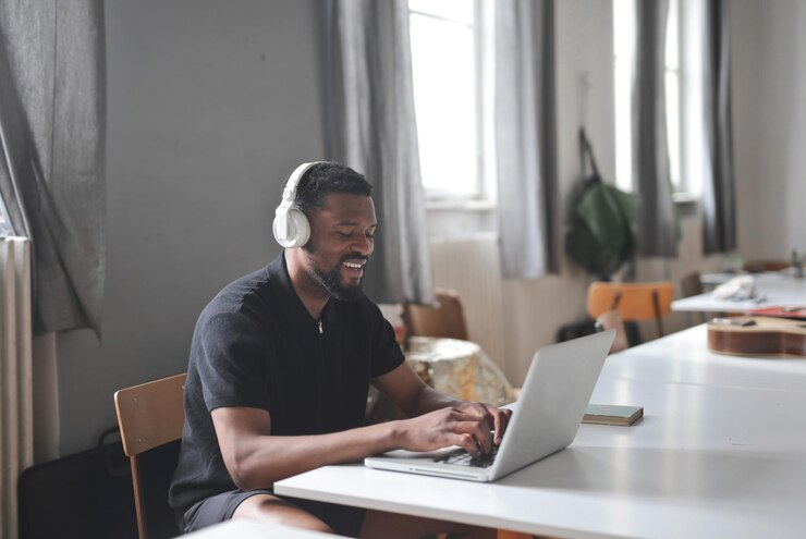 Homem jovem usando um headset no home office.