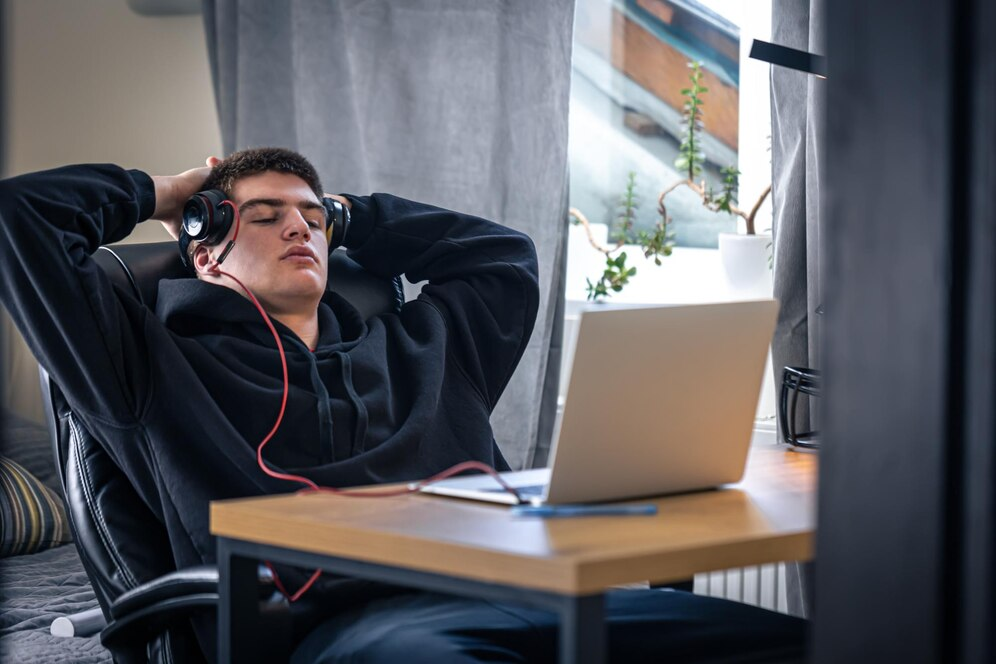 Homem jovem escorado na cadeira, com preguiça - ergonomia no home office