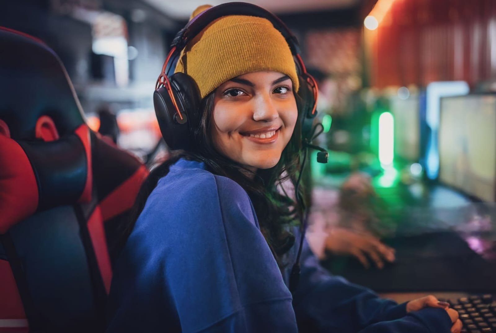 Garota gamer bonita sorrindo usando fone - Melhores fones de ouvido por faixa de preço: R$50, R$100, R$150, R$300, R$500 ou mais