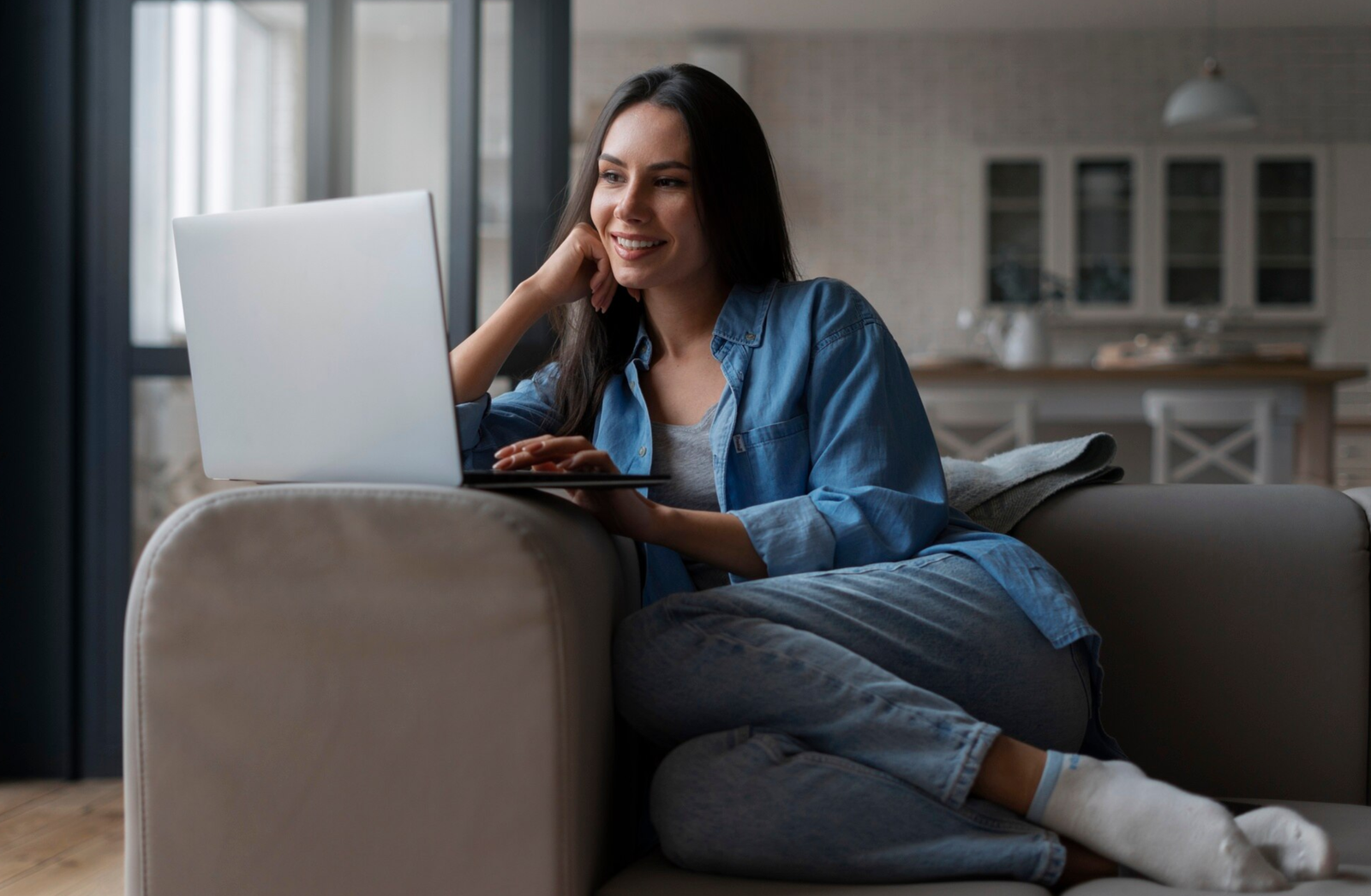 Mulher de meias no sofá usando notebook - Home office renda extra
