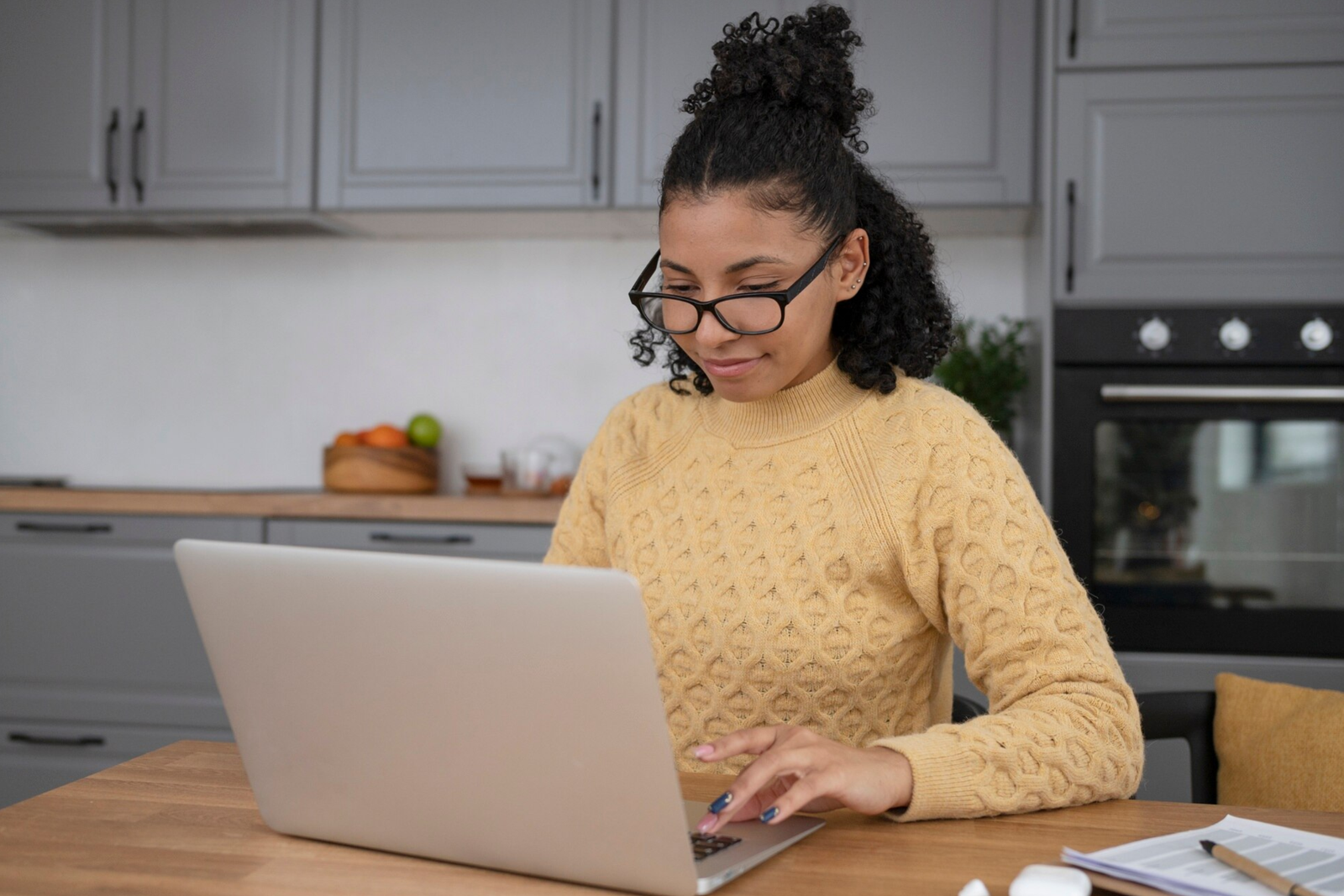 Mulher jovem bela usando notebook na cozinha - Empregos online home office