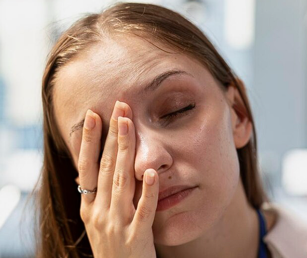 Mulher cansada com a mão sobre os olhos. Fadiga visual.